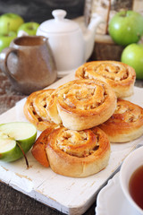Sweet buns with apple and cinnamon, green apples and cup of tea