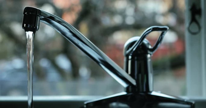 Fresh drinking water pouring from kitchen tap. 4K.
