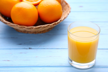 Glass of orange juice with orange on wooden table