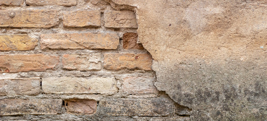 Old brick wall with peel stucco texture. Retro vintage worn wall background. Decayed cracked rough abstract wall surface