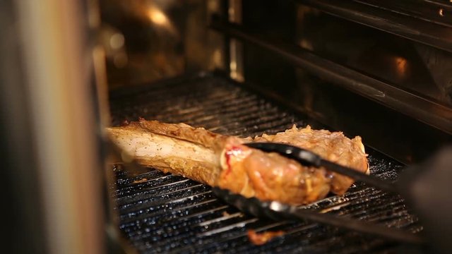 Steak with bone.Cook cooks steak in the oven.