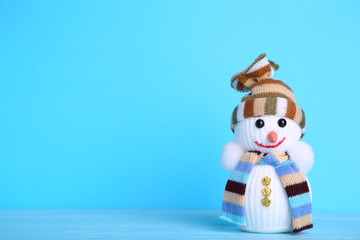 Small snowman toy on a blue background