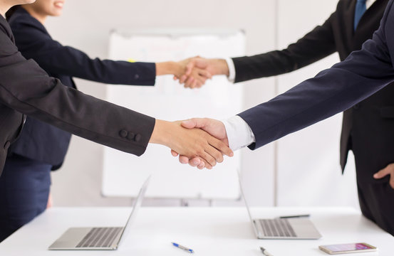 Business team people shaking hands finishing up meeting together in office room