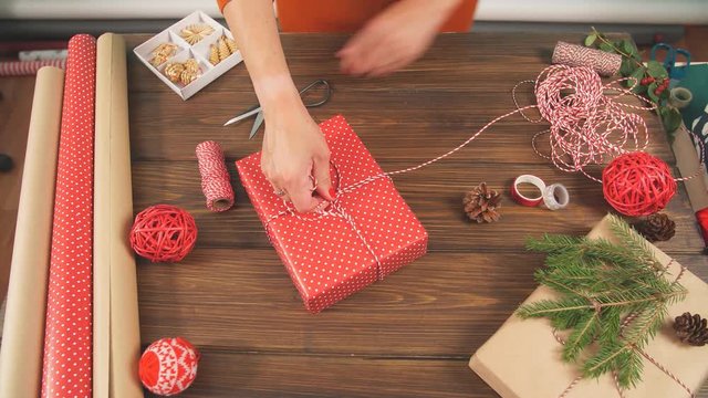 Christmas presents wrapped in eco paper with homemade decoration on wooden background with decor elements and units