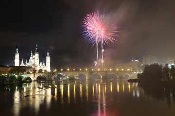 The fireworks during the 2018 Pilar festival next to the Pilar Cathedral and the Stone Bridge over...