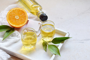 Orange liqueur in glass. Delicious yellow alcohol drink. Citrus liquor. Glass bottle, shot. Copy...