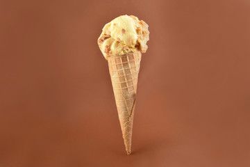 Vanilla ice cream cone stock images. Ice cream on a brown background. Caramel ice cream in a cone