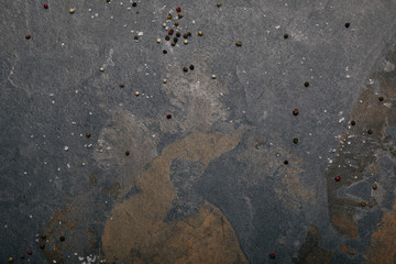 top view of scattered salt and allspice on grey marble background