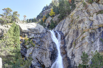 A Caldarès river waterfall during a sunny autumn in the firs and pine trees forest of the rocky...