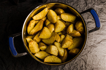American potatoes with salt pepper and cumin in pan.