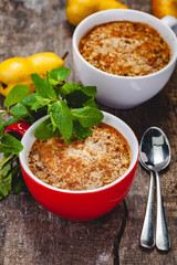 Apple crumble in two cups on wooden rustic background. Close up