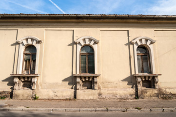 Broken windows of old abandoned house from 17 century view from the street.