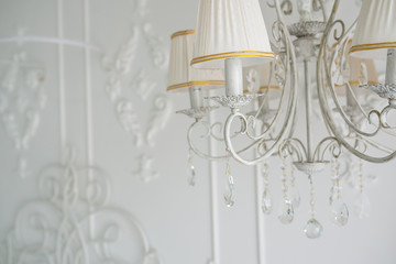 White chandelier in the interior of the bedroom