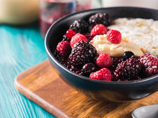 Vegan cashew milk Chia pudding with berries and home made almond butter served in a bowl on wooden board