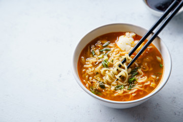 Easy japanese ramen with noodles, pork broth, egg and leek in white bowl on concrete background with copy space