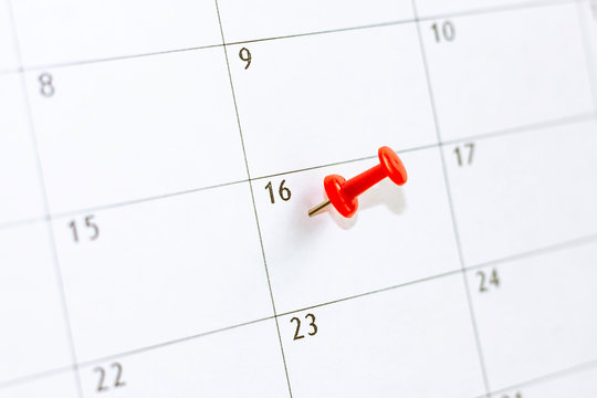 16 date pinning on calendar with Red color pin thumbtack. Save the Date.