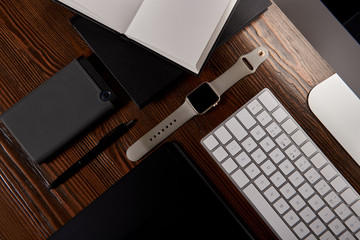 top view of designer workplace with various gadgets on wooden table