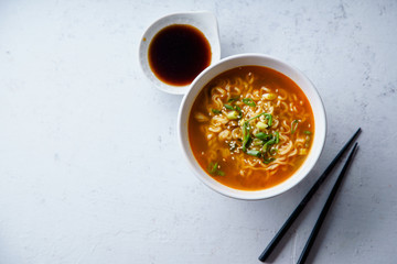 Overhead image of easy japanese ramen with noodles, pork broth, egg and leek in white bowl on...