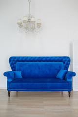 Blue elegant sofa against the background of the white wall