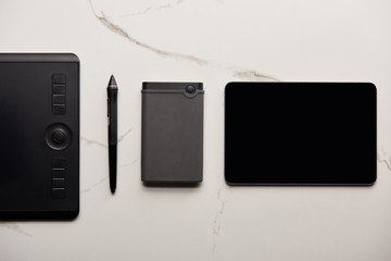Obraz premium top view of graphics and digital tablet with portable hdd on white marble surface