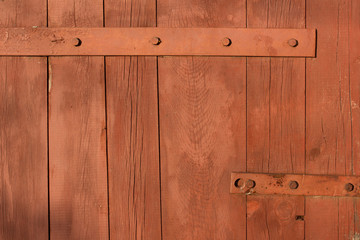 Forged metal hinge for gates and doors in the old style. Sharp curls of the iron door canopy are handmade by the blacksmith. Metal detail on the wooden surface