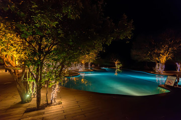 Open swimming pool with trees around it in evening