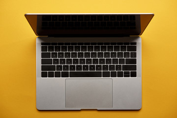top view of opened laptop on yellow surface