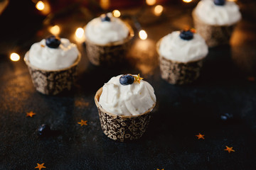 Festive dessert on a black background. Cakes with cream and berries for Christmas