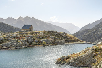 A lodge in the Balchimaña artificial lake, among barren rocky mountains and a blue sky in a sunny...