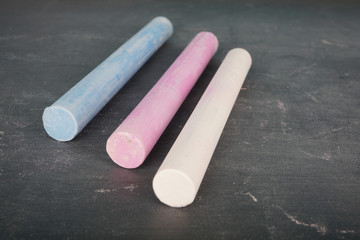 Coloured chalk over chalkboard. Selective focus