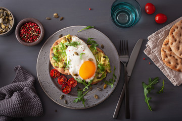 breakfast avocado sandwich with fried egg and tomato