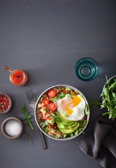 quinoa bowl with fried egg, avocado, tomato, rocket. Healthy vegetarian lunch