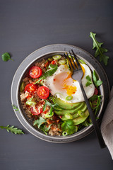 quinoa bowl with fried egg, avocado, tomato, rocket. Healthy vegetarian lunch