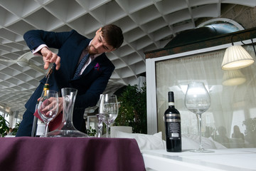 the young male sommelier while tasting red wine