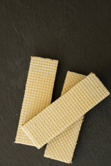 Wafers with chocolate on black slate board, close-up