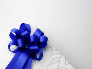 royal blue ribbon bow on white gift box on composition space 