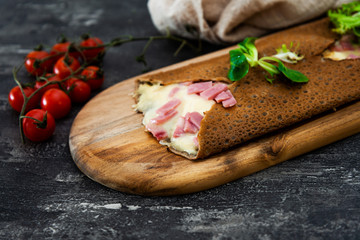 Black wheat and wheat galette topped with cooked ham and emmental cheese