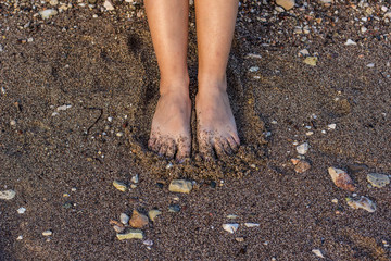 female feet on a wet sand background texture near water sea shore line nature local place