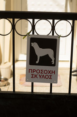 Warning sign "Beware of dog" with the inscription in Greek on the island Crete
