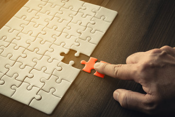 Hand of businessman holding last piece jigsaw puzzles,Business success concept