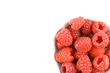 fresh red raspberry fruits in a small white bowl