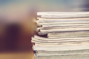 Stacked Magazines on light background, close-up view