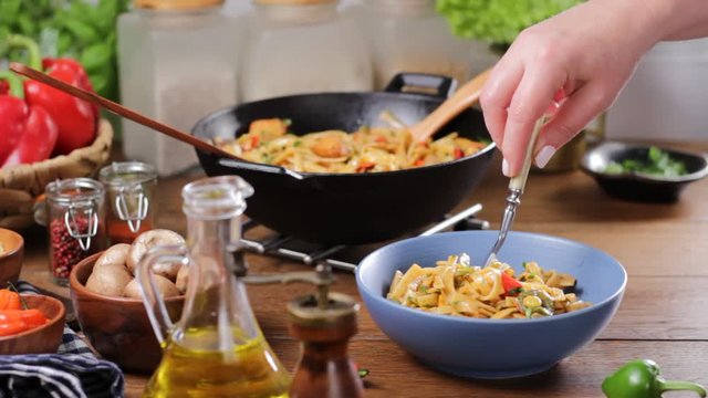 Indonesian pasta with chicken, pieces of bamboo and mushrooms.Seasoning, mixing, sprinkling and translating the dish.
