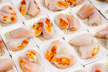 Vegetable spring rolls wrapped in rice paper cut in half in a sauce-pan with a spicy sauce. Catering concept vegetarians birthday, healthy nutrition