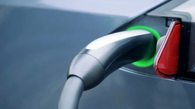 Modern equipment charges an electric vehicle, close up.