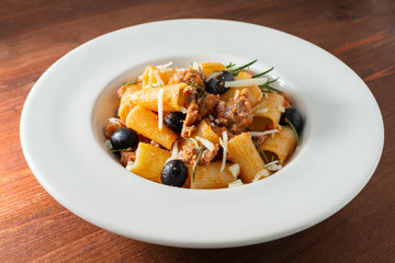 Piatto di mezze maniche con salsiccia, olive e formaggio