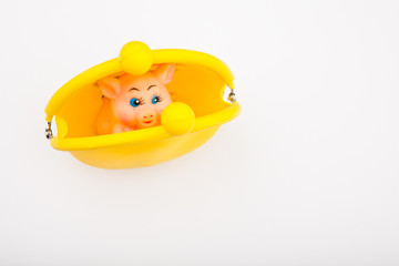 Toy pig yellow purse white background 