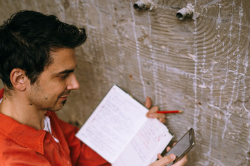 Repairman using notebook and smart phone
