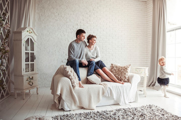 Obraz premium happy young family resting in living room on Sunday