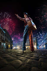 Night street circus performance whit clown. Festival city background. fireworks and Celebration...